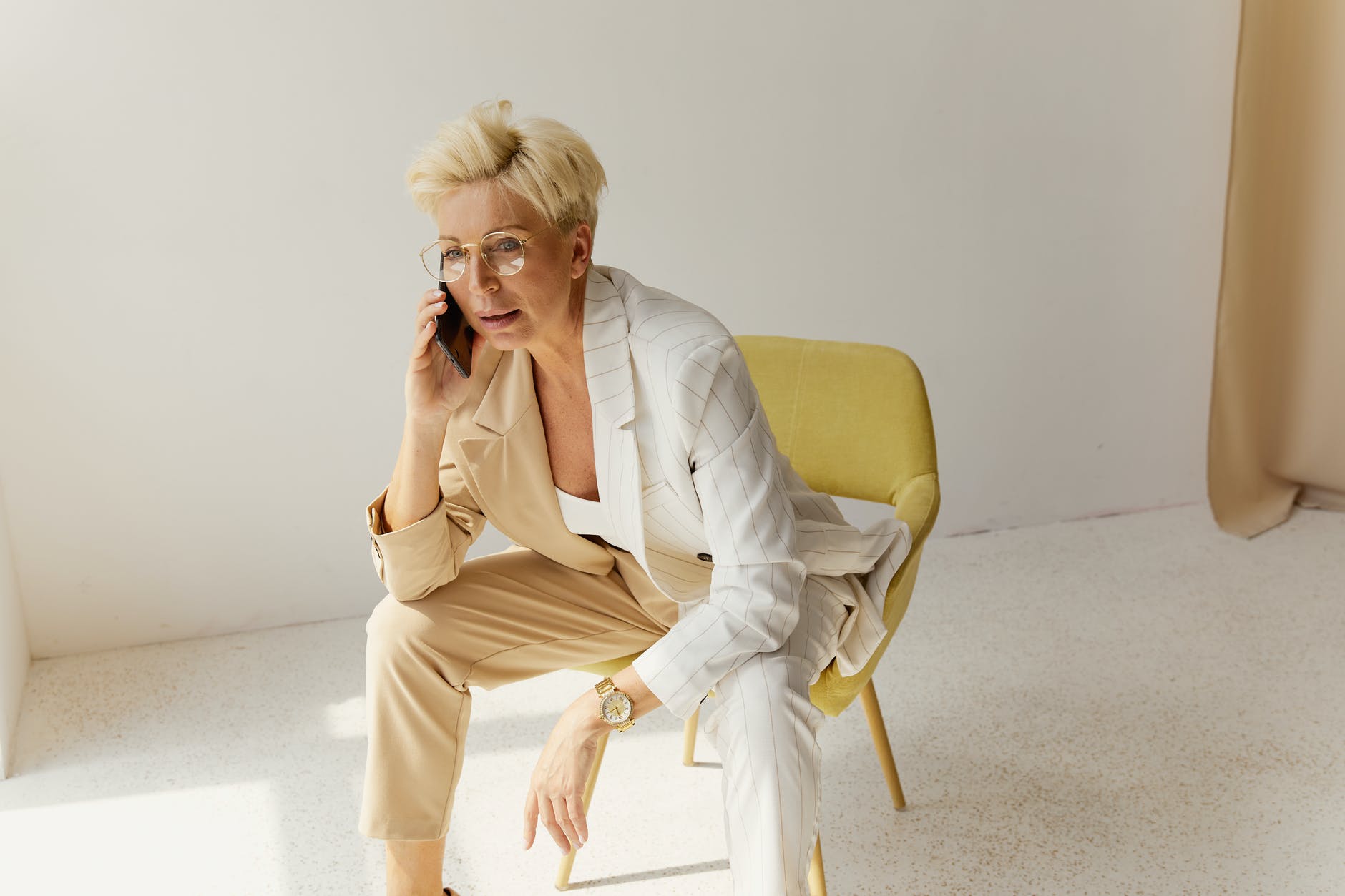 woman wearing beige blazer talking on the phone