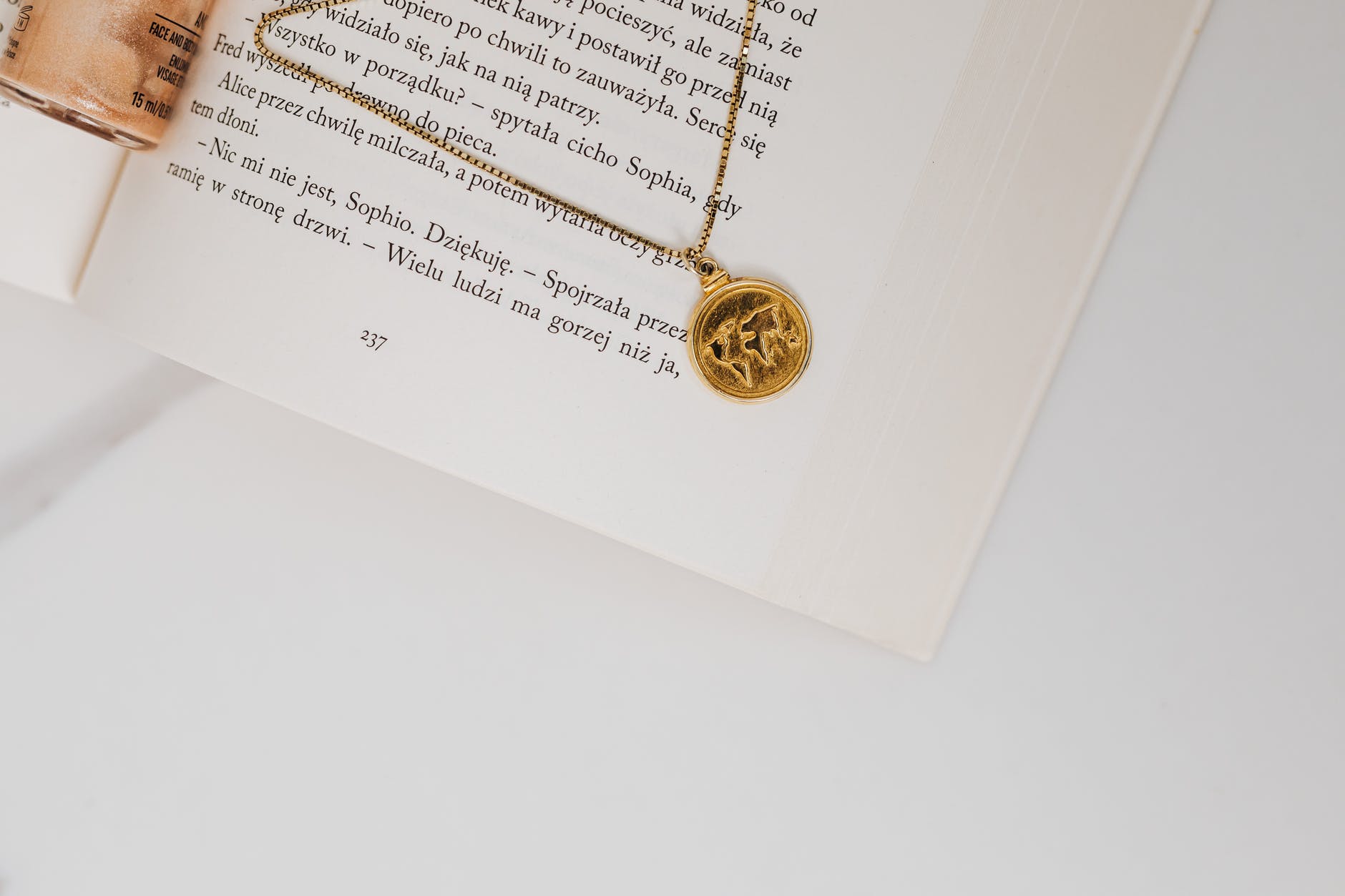 gold necklace with pendant on a book page
