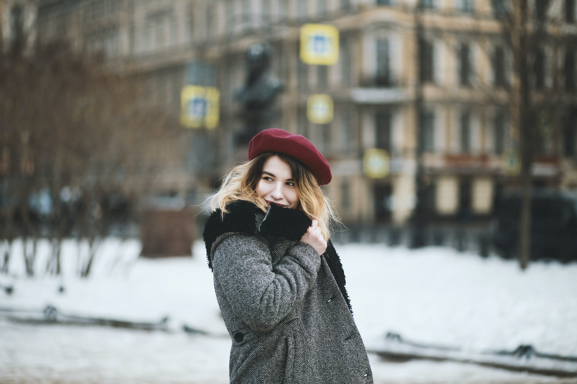 woman wearing coat and red hat during snowy day fashionable style winter tips fashion stay fashionably warm this winter 
