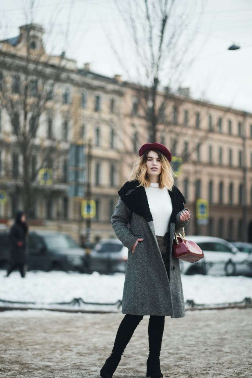 woman standing near bare tree fashion fashionable winter style tips fashionably warm this winter 